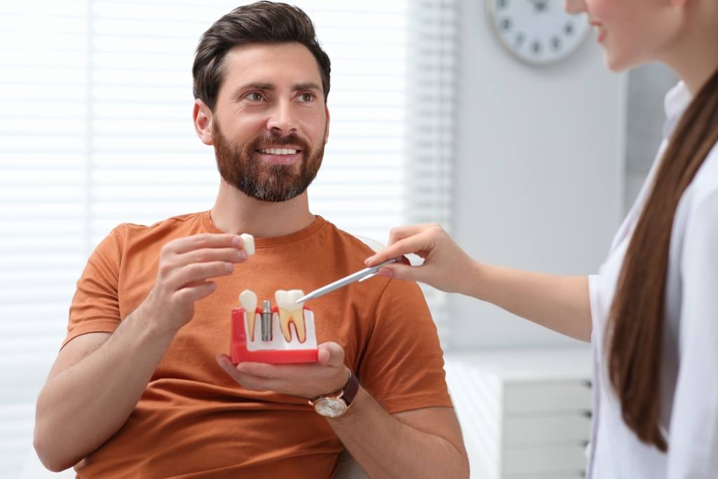 A man looking at different types of dental implants