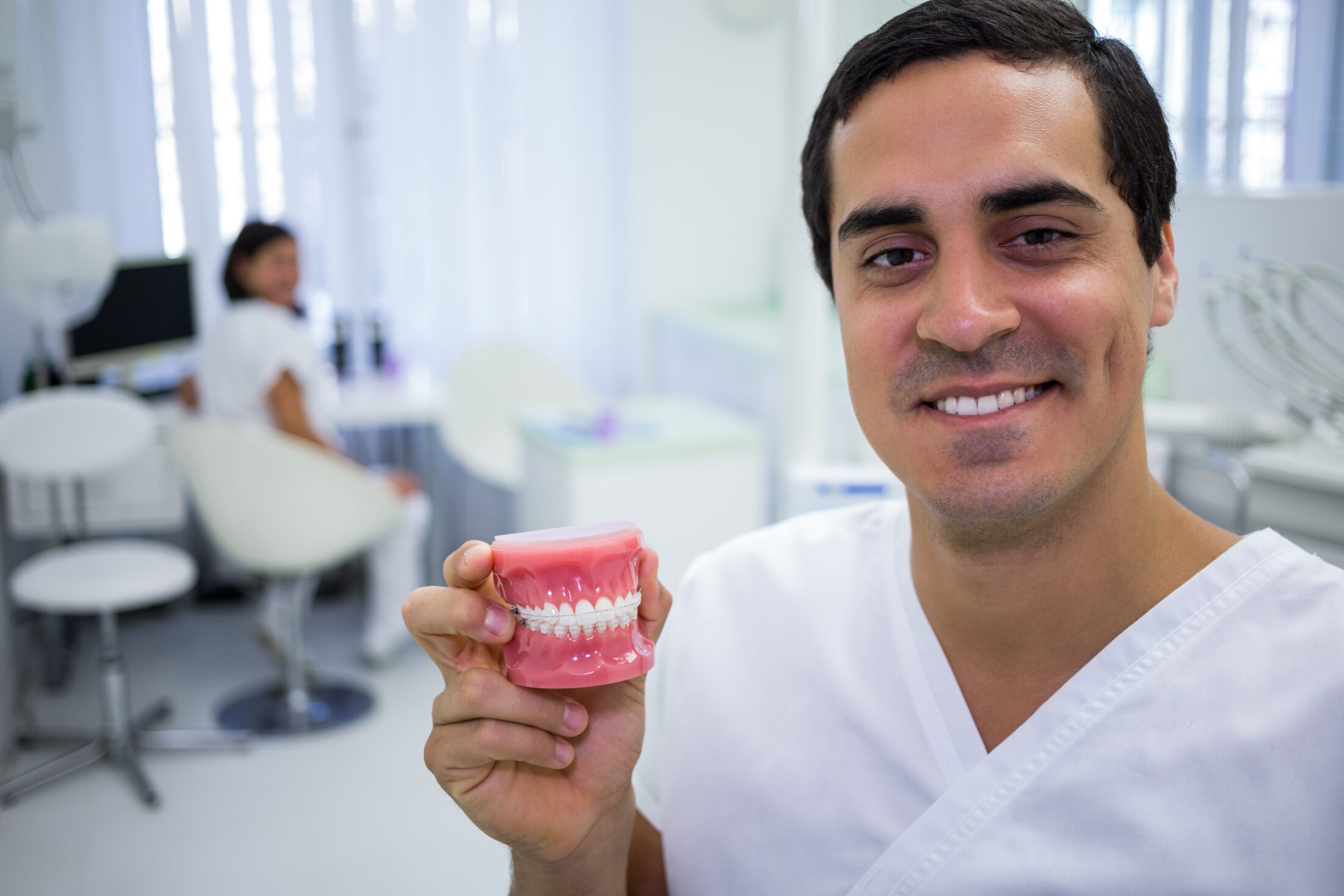 Portrait of dentist holding a set of dentures in the clinic Star Dental | Dental Implants